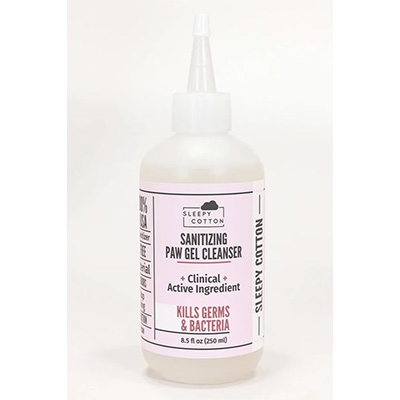 A plastic squeeze bottle of Sleepy Cotton Sanitizing Paw Gel Cleanser with a pointed applicator tip. The label is pink and white, highlighting that it contains a clinical active ingredient and kills germs and bacteria.